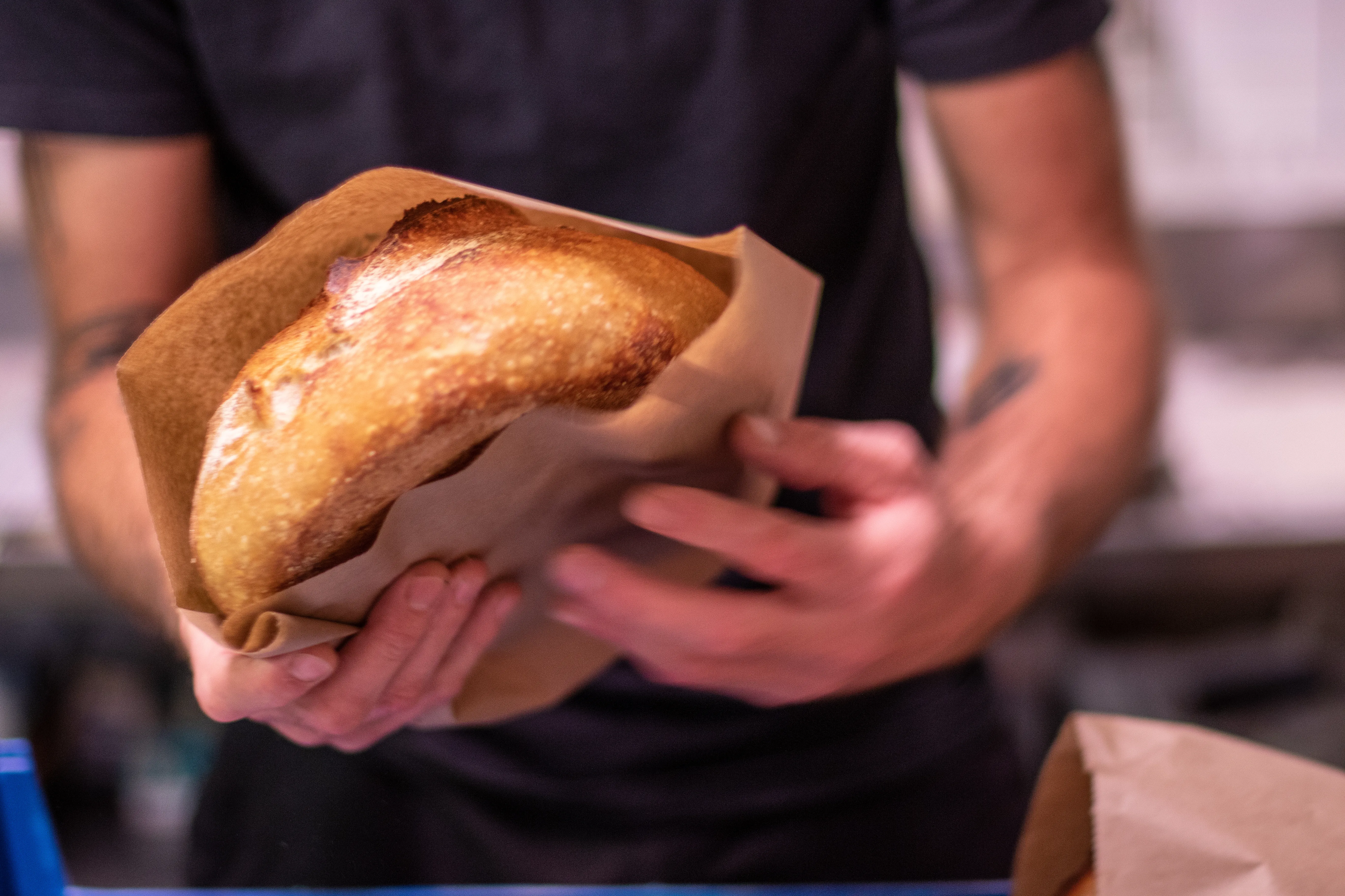 Bread being moved in paper bag