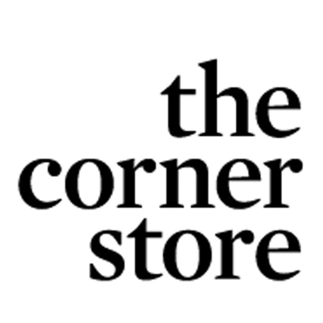 A man making a coffee, looking out to the tables in the cafe